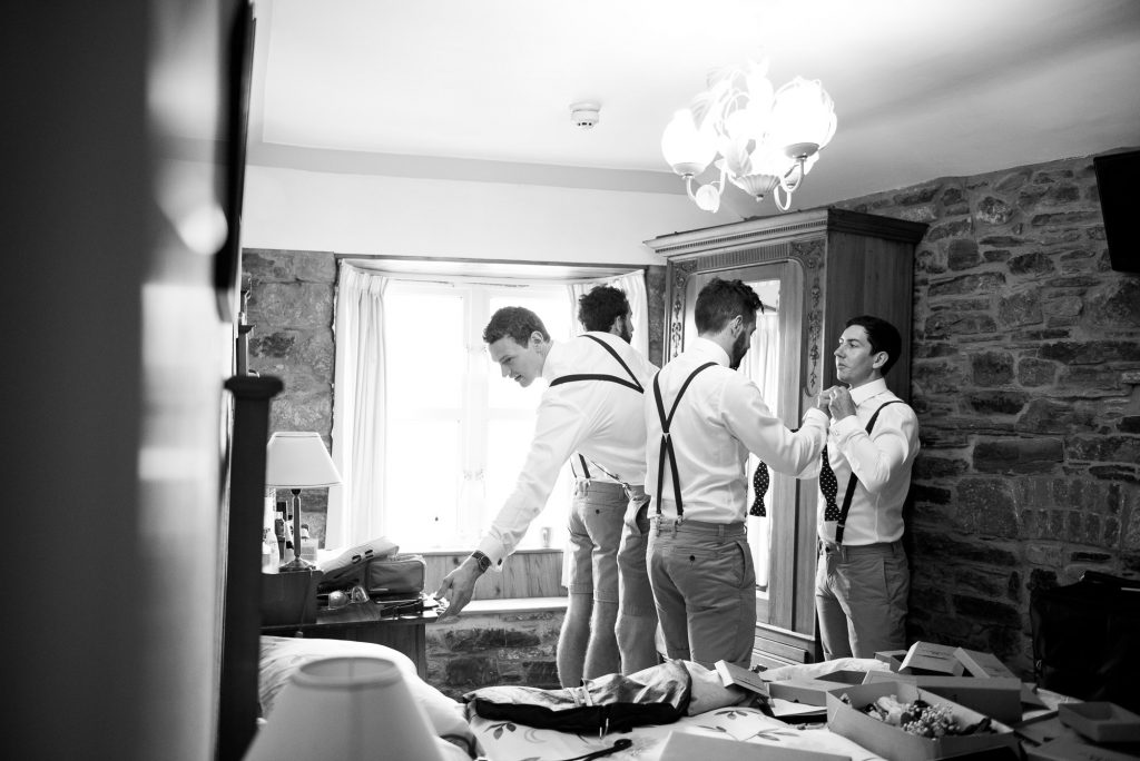 Groom with groomsmen preparing pre wedding photography Cornwall