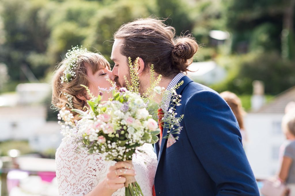 Bridesmaid kissing husband Cornwall beach wedding