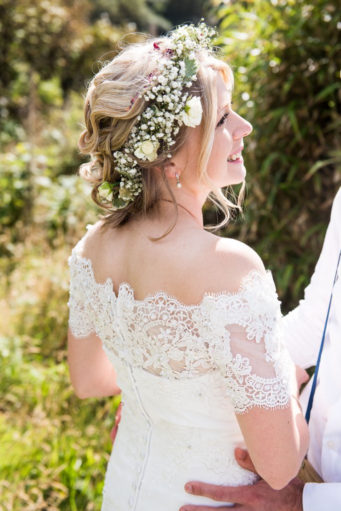 Smiling boho bride wearing Gysophila floral crown Driftwood Spars Wedding