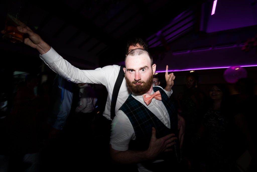 Funky groom with best man on dance floor Berkshire
