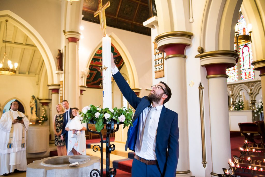 Godfather lights a candle in Christening ceremony Chelmsford