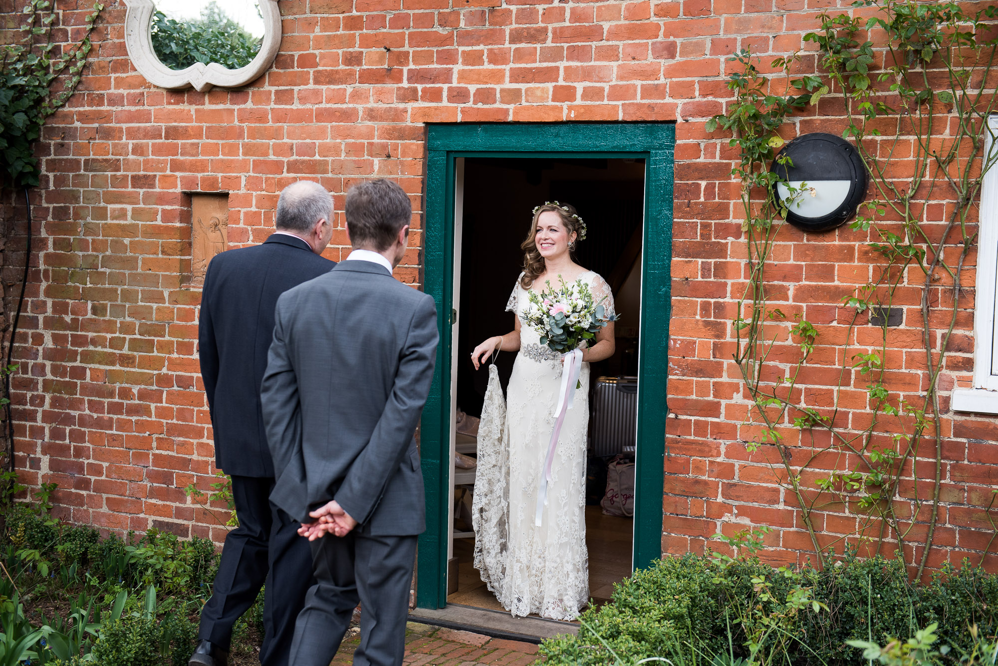 bride greeted by both her dads to walk her down the aisle