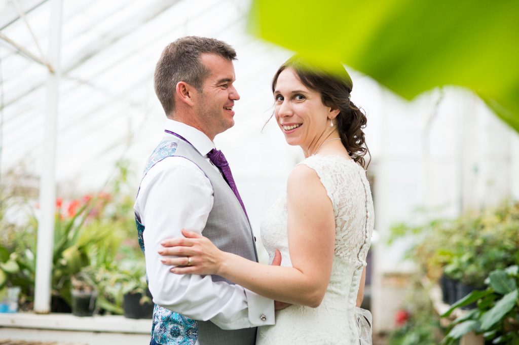 Smiling bride in greenhouse foliage Surrey wedding
