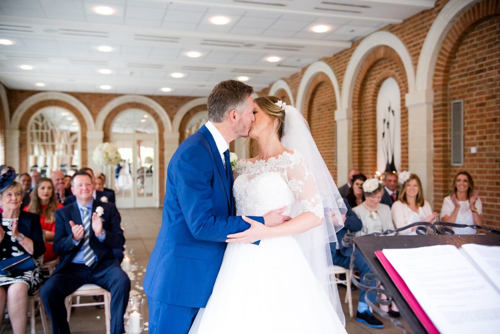 Great Fosters. Natural Wedding Photography. The Newly Married Couple Share Their First Kiss.