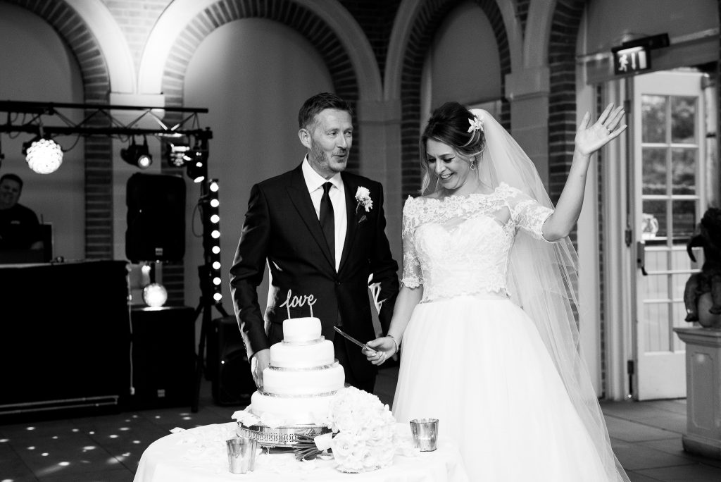 Great Fosters. Natural Documentary Wedding Photography, Surrey. The Bride and Groom Cut The Cake.