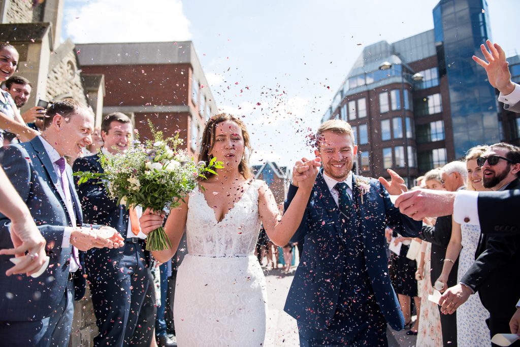 Wedding Confetti, Fun Documentary Wedding Photography Surrey, Couple Cheer as They Walk Down The Confetti Line