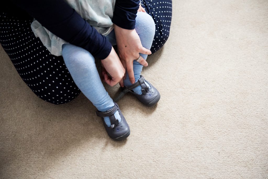 Surrey Family Photography, Family photographer, Candid moment of mother putting on her babies shoes