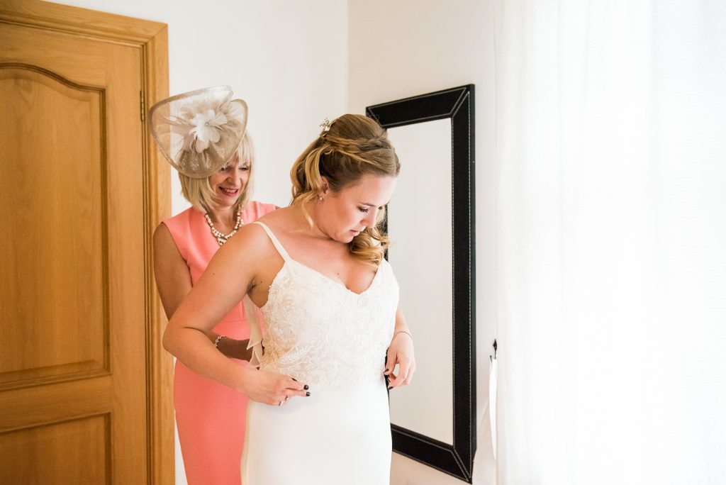 Outdoor Wedding Ceremony, Surrey Wedding Photography, Mother Of The Bride Helps Her Daughter Into Catherine Deane Bridal Dress