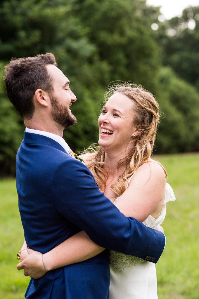 Outdoor Wedding Ceremony, Surrey Wedding Photography, Bride and Groom Smile and Laugh Together as They Embrace