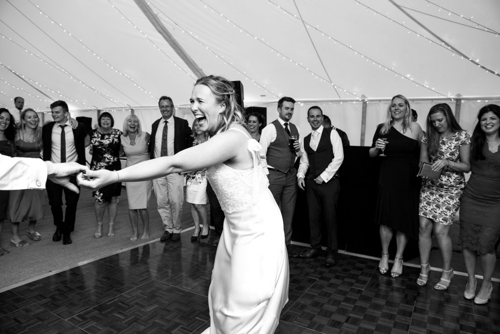 Black and White Photograph Of Bride and Groom Share an Energetic and Lively First Dance