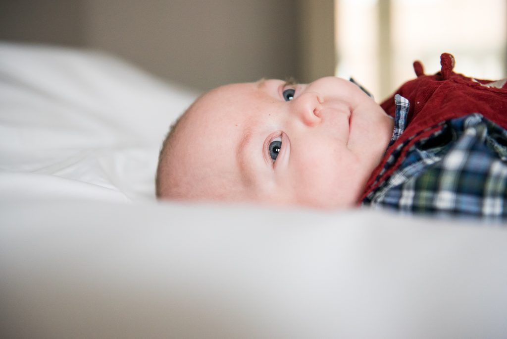 Newborn Photography Guildford, Christmas Family Shoot, Baby On The Bed Looking To Camera
