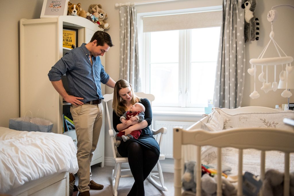Newborn Photography Guildford, Candid Photograph of Mother, Father and Baby in Nursery