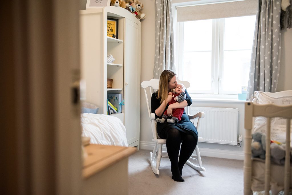 Newborn Photography Guildford, Candid Photograph of Mother and Baby in Nursery