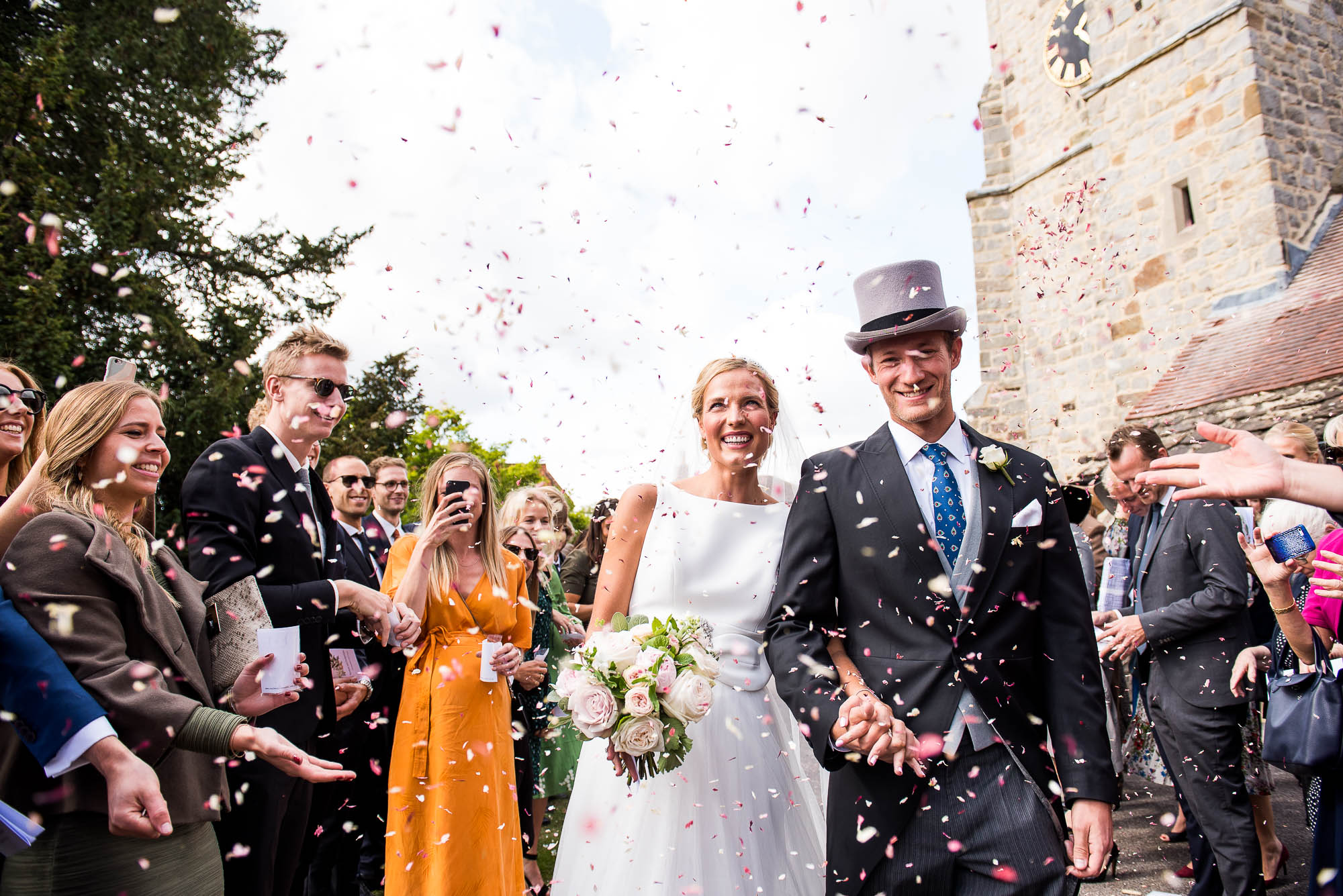 Outdoor Wedding Photography Surrey, Stunning Scandinavian Couple Smiling as They Walk Down The Confetti Line