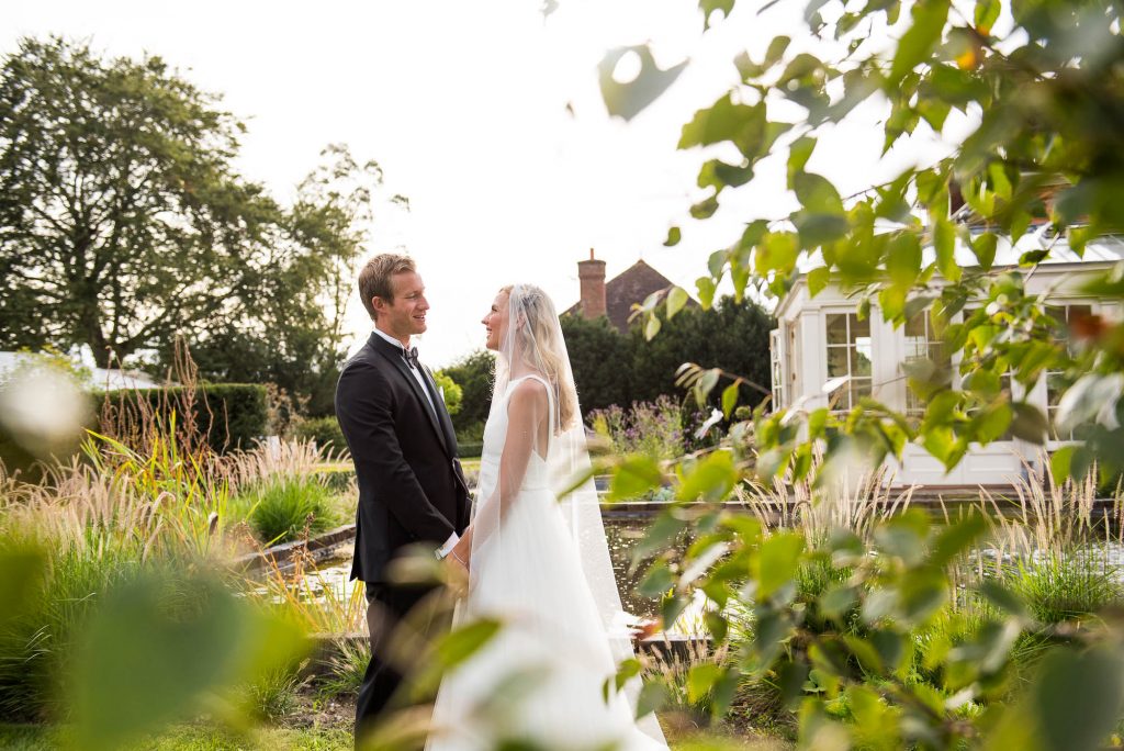 Outdoor Wedding Photography Surrey, Bride and Groom Stare Lovingly At Each Other Bathed in Golden Evening Light, Miss Bush Bridal