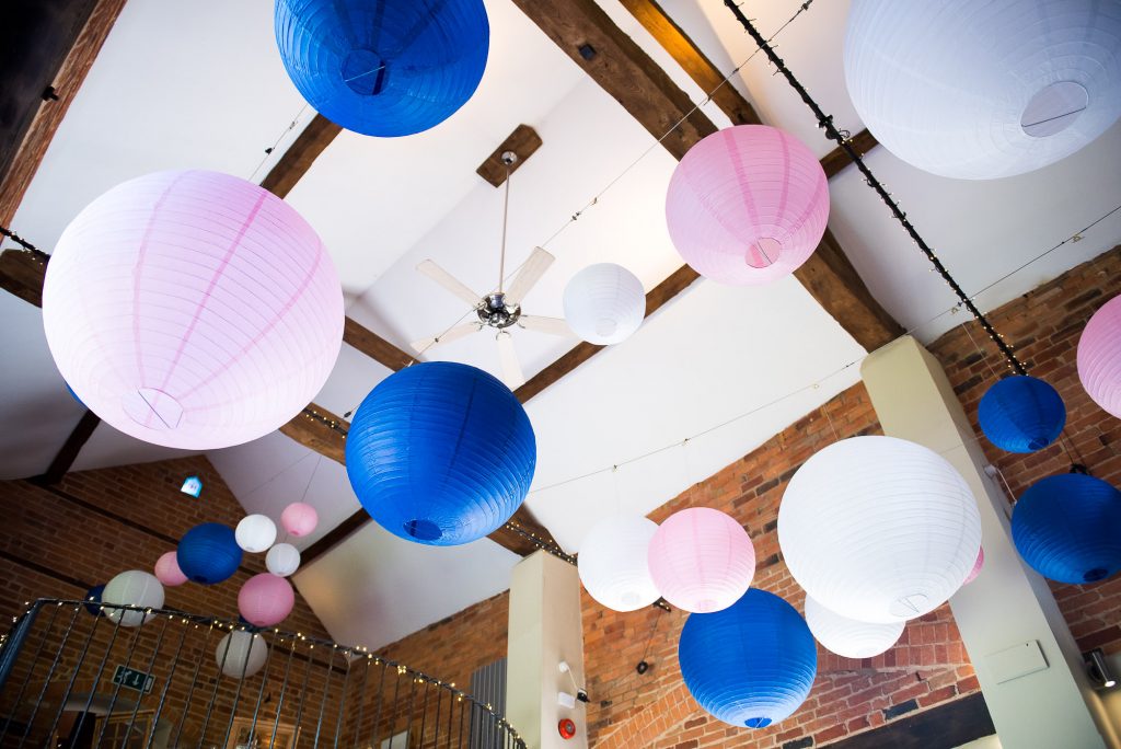 lgbt wedding photographer, wedding reception room decorated with assorted pastel paper lanterns