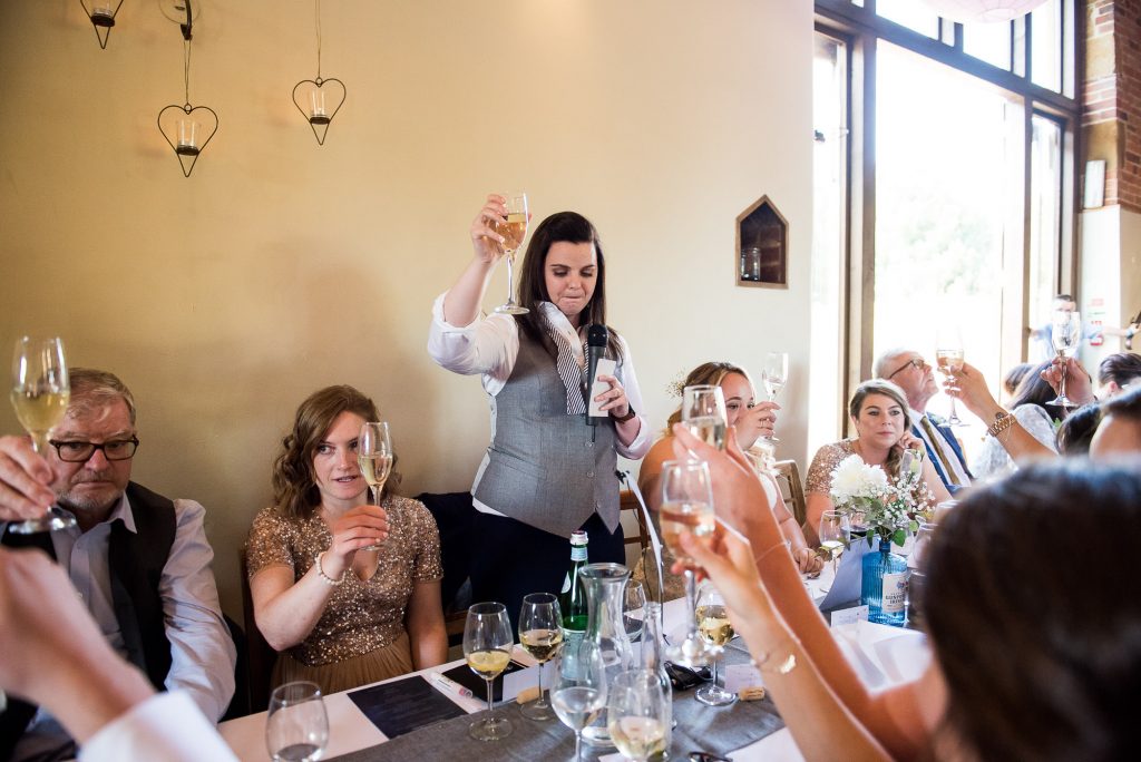 lgbt wedding photographer, bride gives a toast to the wedding party, Dodmoor House Wedding
