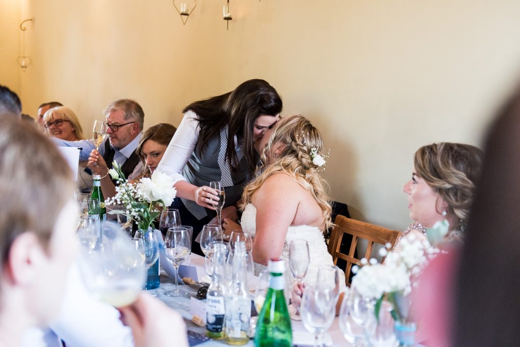 lgbt wedding photographer, Brides share a kiss during speeches, Dodmoor House Wedding