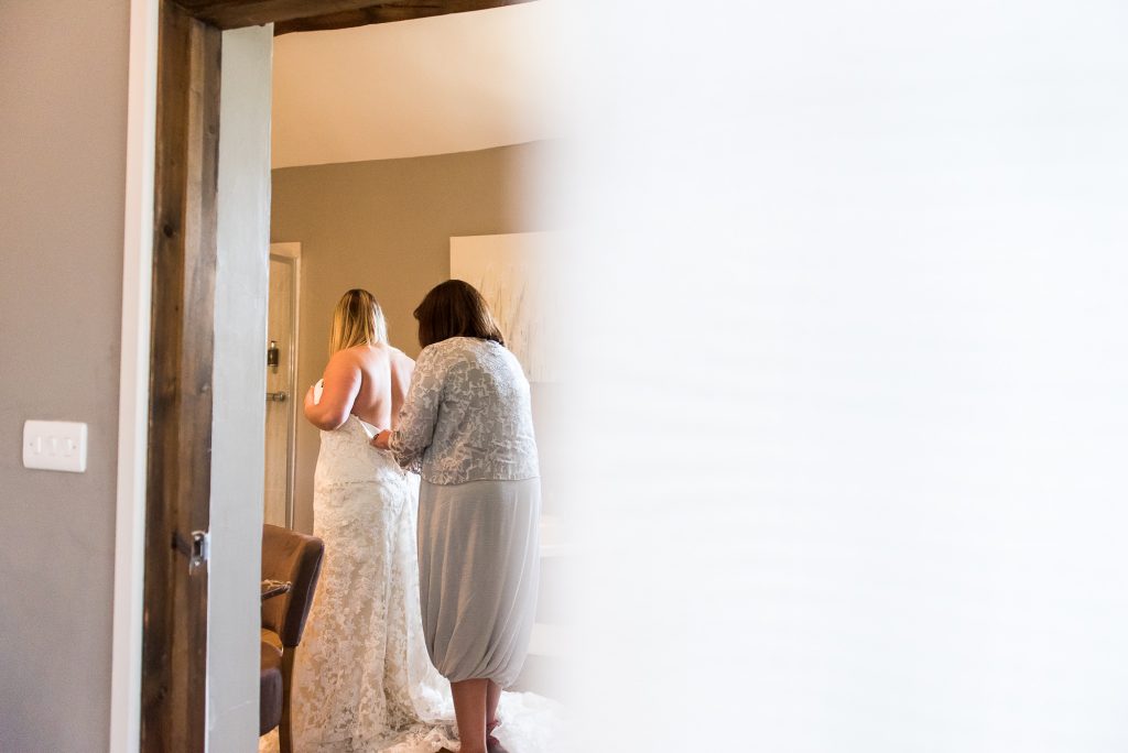 lgbt wedding photographer, Natural bridal photography, Mother helps her daughter into her wedding dress