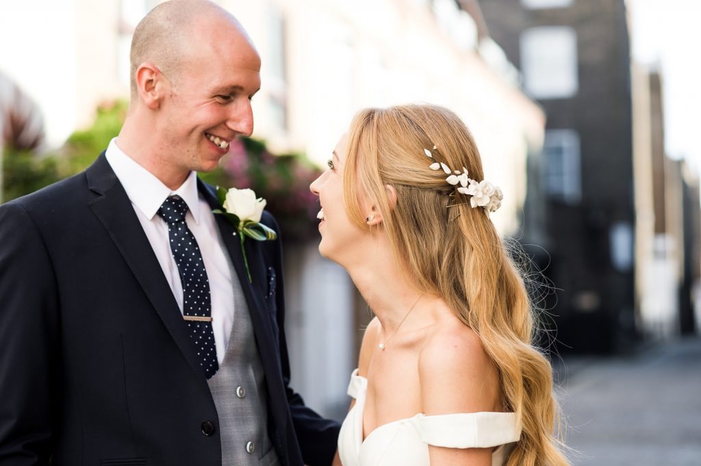 Old Marylebone Town Hall Wedding, couple smile and laughing with each other, natural wedding portrait