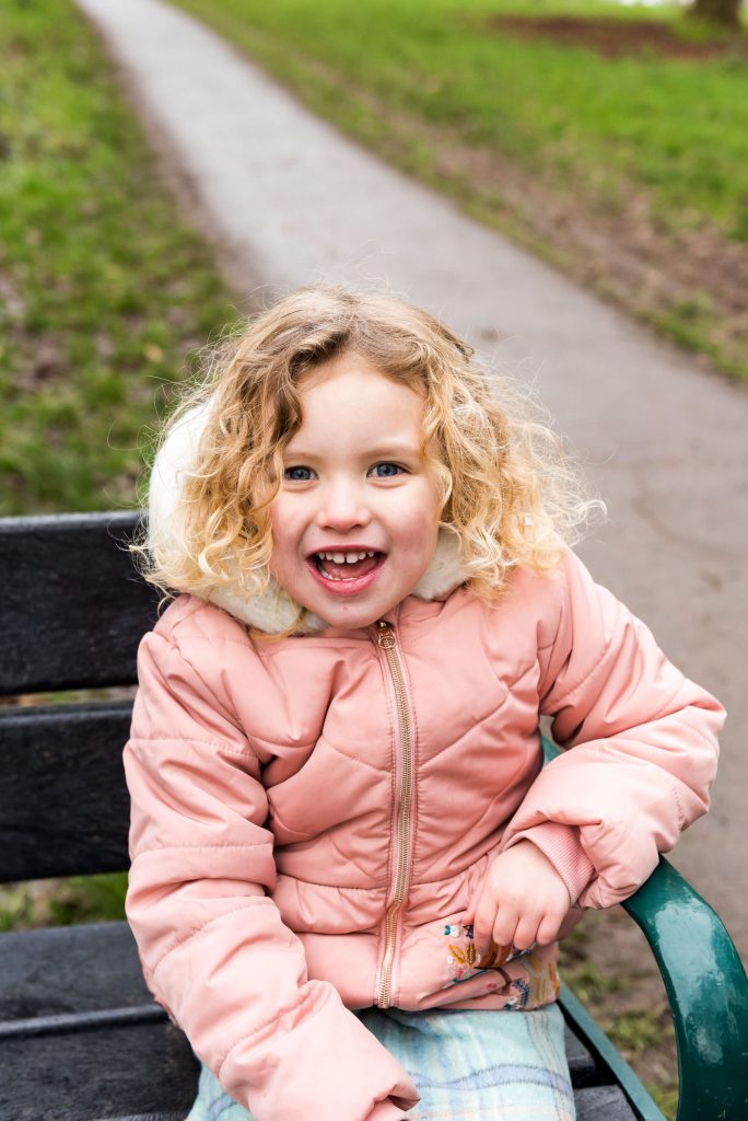 family photography guildford, candid childhood portrait of little girl with gorgeous curly blonde hair