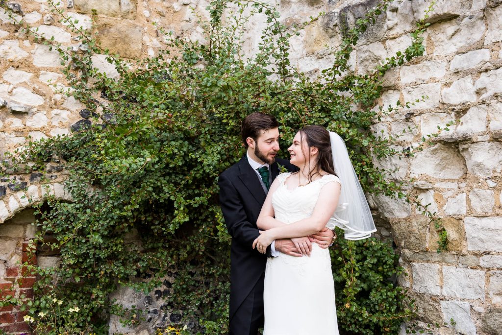 Alternative wedding photography - couple embrace in Guildford castle gardens