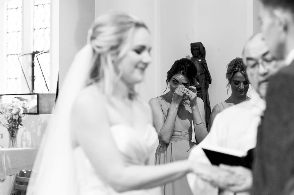 bridesmaid tears up as bride and groom say vows