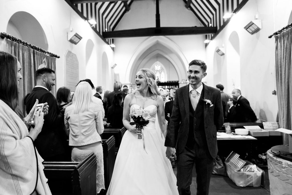 newlywed couple walk back down the aisle together