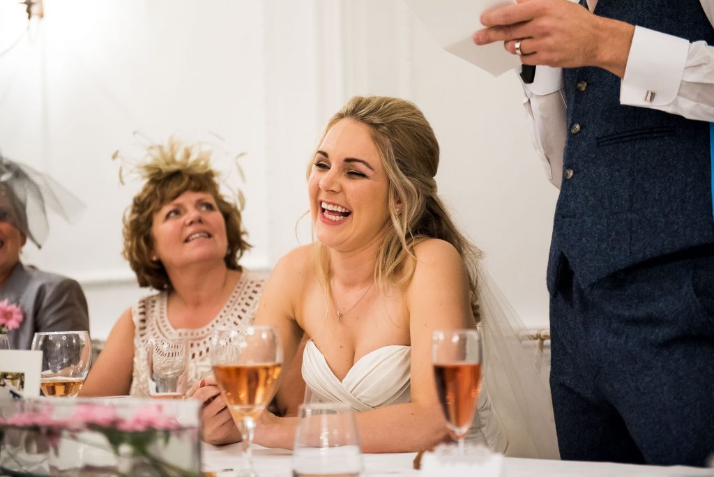 bride laughs sweetly at groom's speech