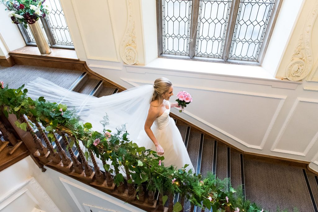 bride descends down the staircase at Horsley Towers