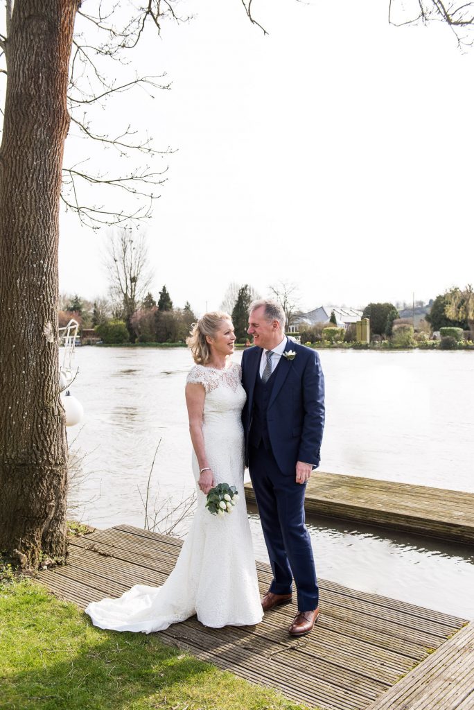 Couple stand beside each other beside the river