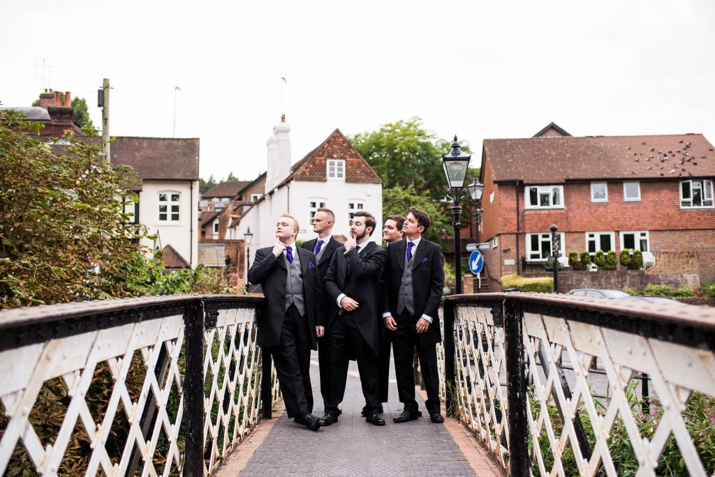 Groomsmen pose for comical group photographs before the wedding ceremony