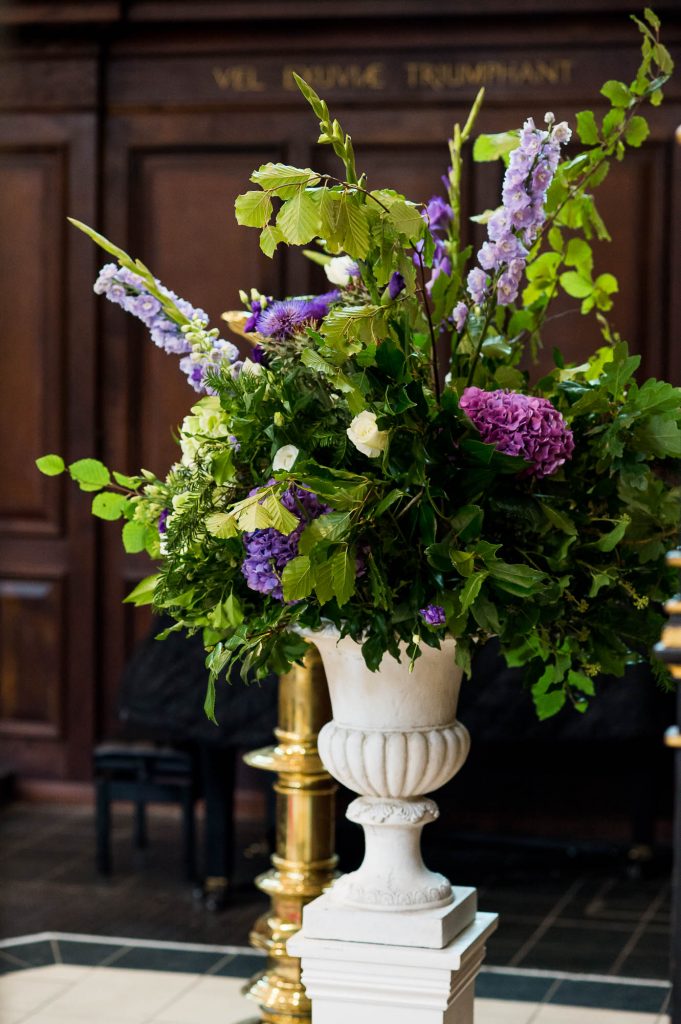 Purple, green and white ceremony flowers in rustic arrangements