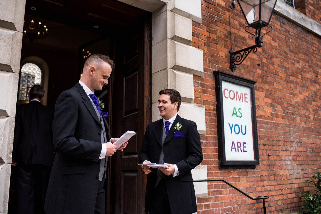Groomsmen greet guests outside Holy Trinity Church Guildford