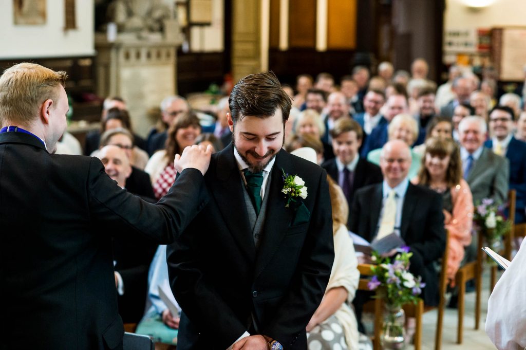 Groom waits at the alter and is comforted by his best man