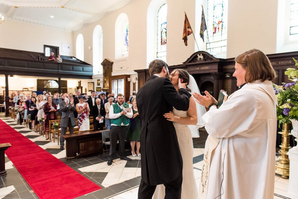 Bride and groom share passionate first kiss during Holy Trinity Church ceremony in Surrey