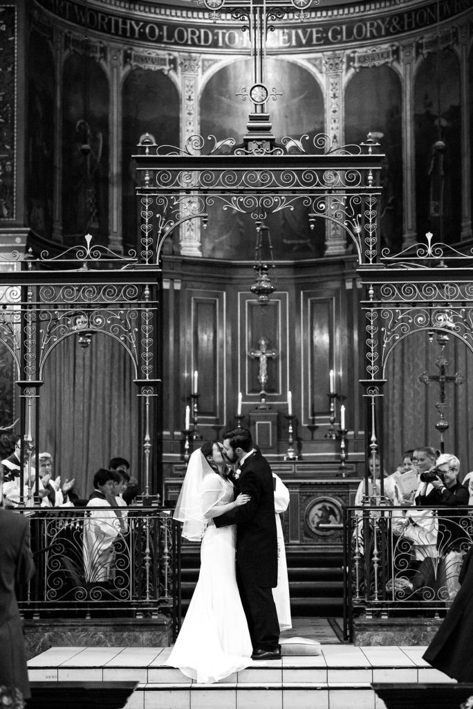 Bride and groom share passionate first kiss during Holy Trinity Church ceremony in Surrey