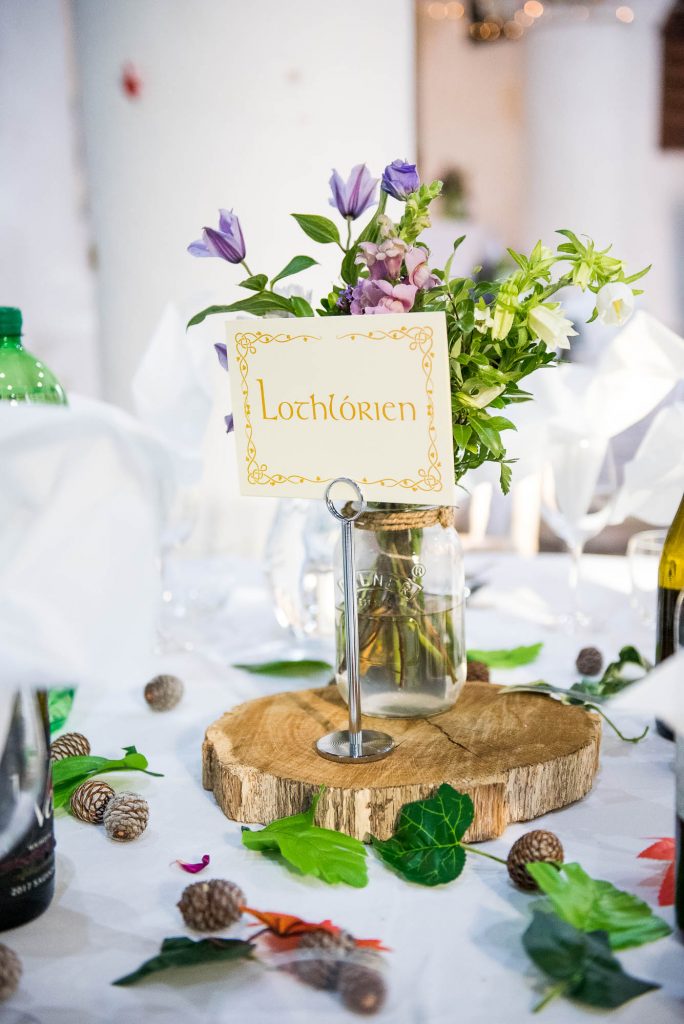 Wedding breakfast table decorations with bouquets in jam jars atop of wooden centre pieces