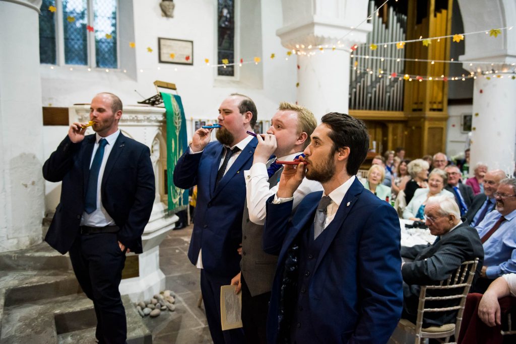 Documentary wedding photographer surrey, Groomsmen sing a song as part of the speeches