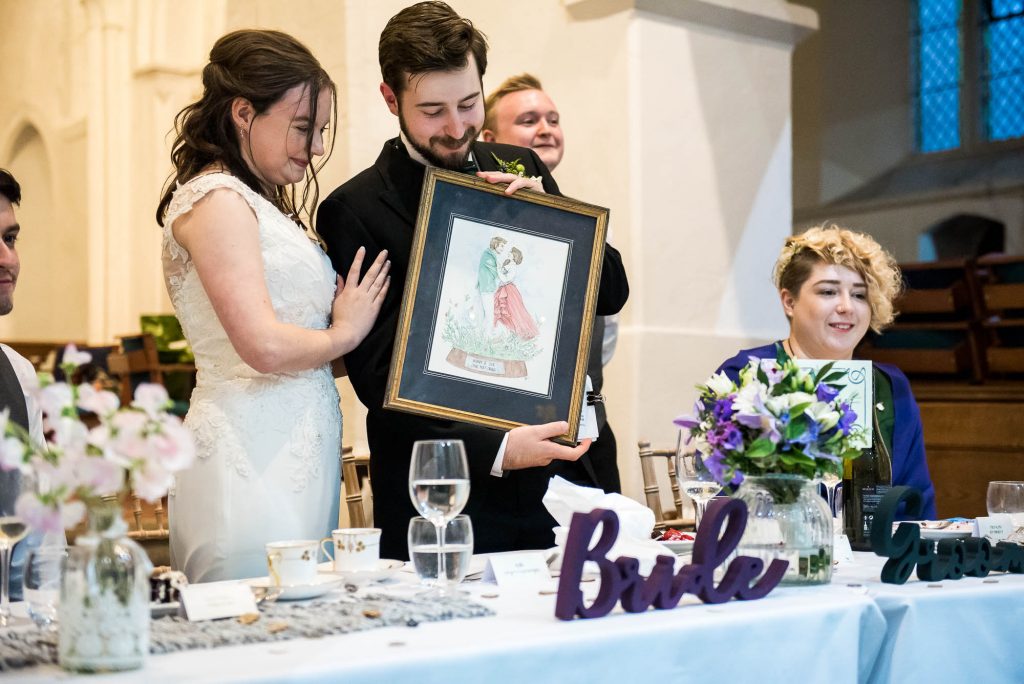 Documentary wedding photographer surrey, Bride and groom receive a personalised drawing as a wedding present 