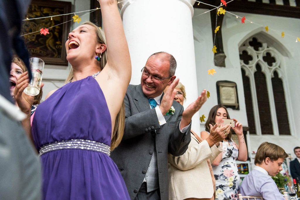 Documentary wedding photographer surrey - Cheering guests smile and clap at first dance