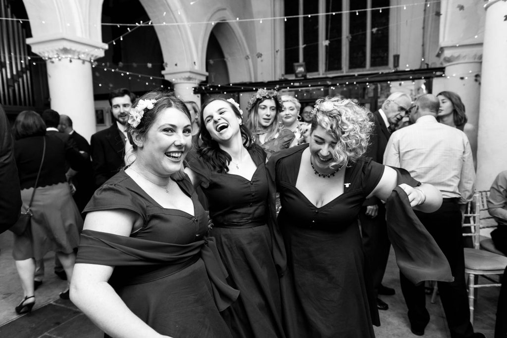 Bridesmaids lively dance together and laugh, Documentary wedding photographer surrey