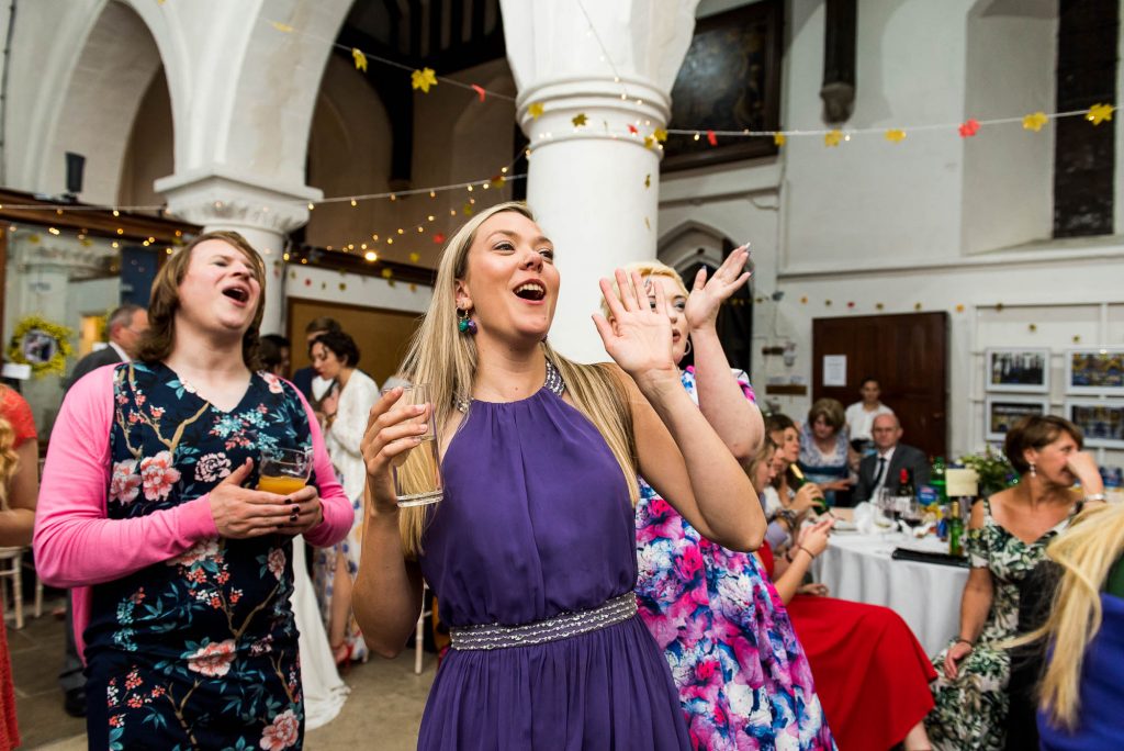 Cheering guests smile and clap at first dance, Documentary wedding photographer surrey