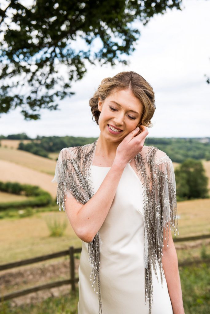 Bride smiles sweetly in silk wedding dress at Botley Hill Barn Farm