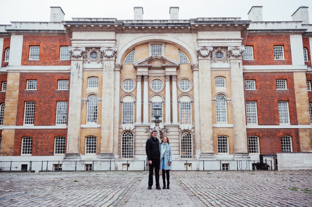 Couple stand in the centre of a Greenwich courtyard 