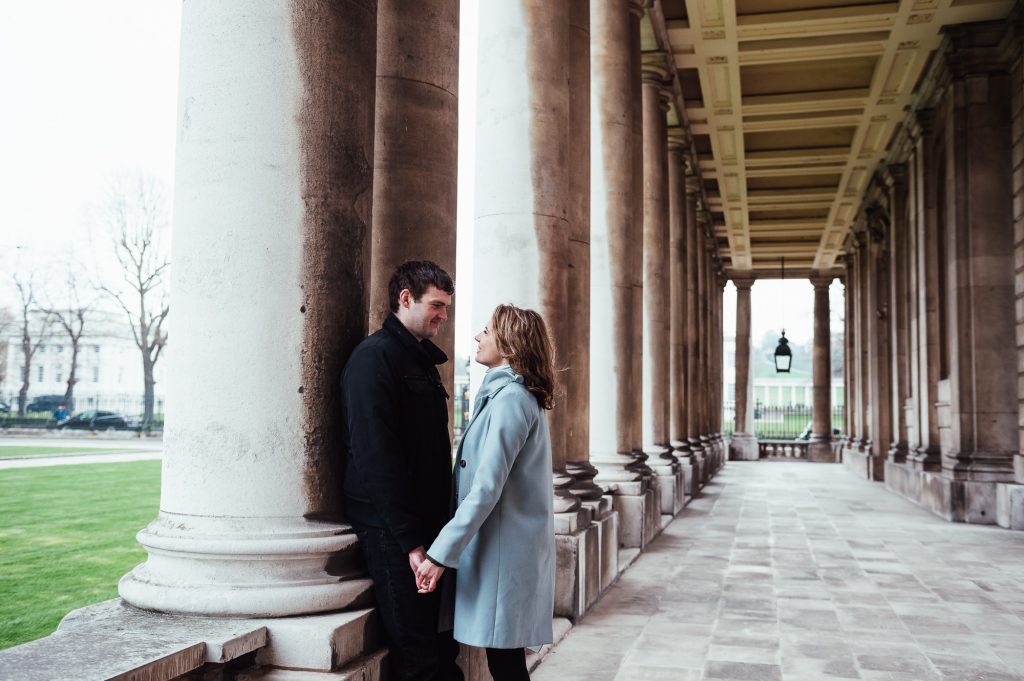Couple embrace in the columns of Greenwich Maritime College