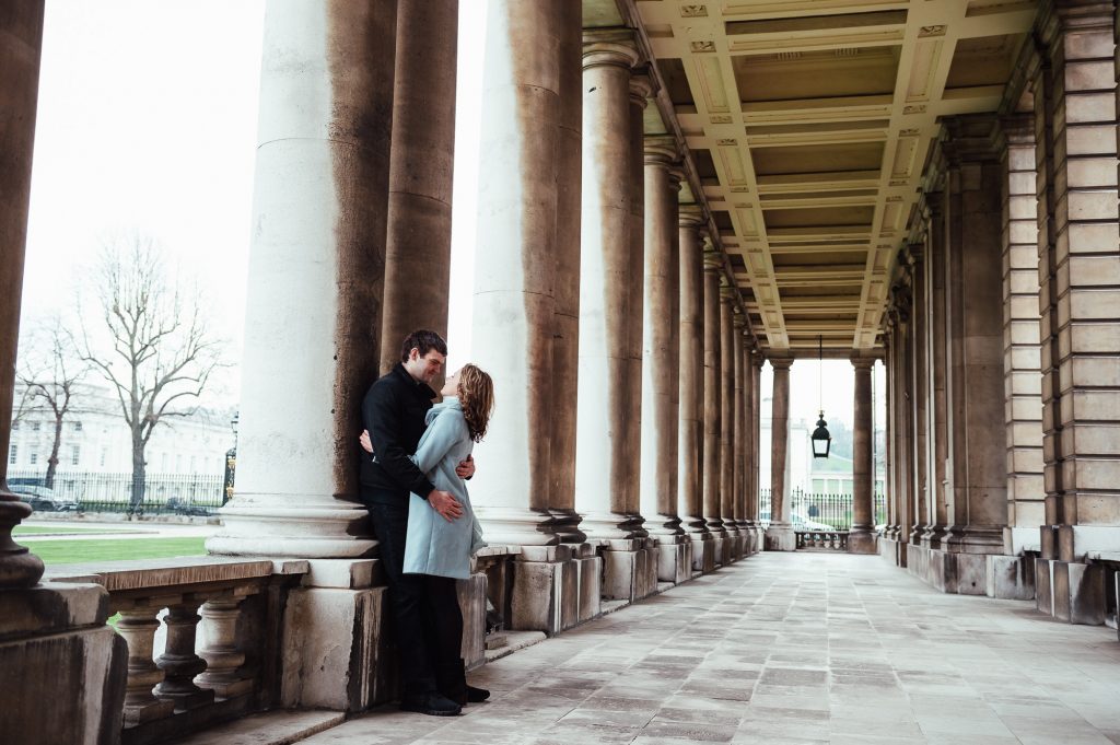 Couple embrace in the columns of Greenwich Maritime College