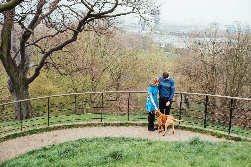 Couple greet a dog in Greenwich Park