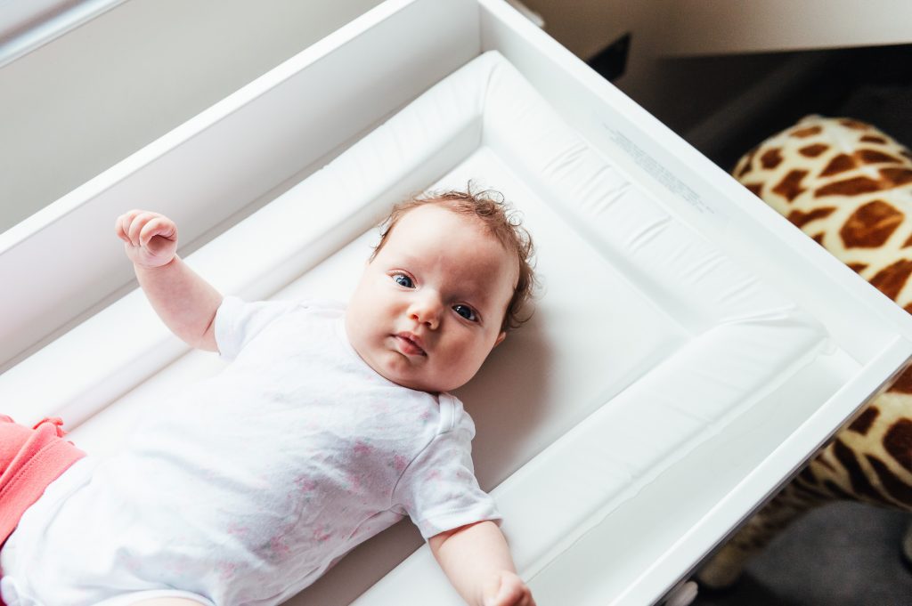 Baby stares at the camera whilst on a changing table