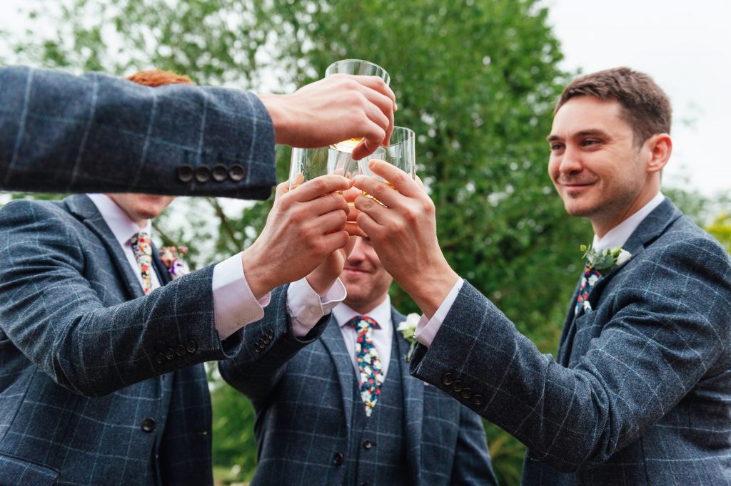 Groomsmen cheers together on a wedding morning